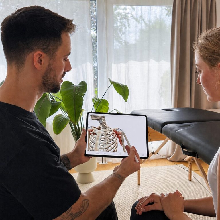 Verständliche Beratung und individuelle Physiotherapie / PhysioNico Köln Physiotherapeut Nico Mauelshagen erklärt einer Patientin am iPad anatomische Zusammenhänge für ihre individuelle Behandlung.